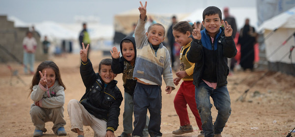 ZAATARI, JORDAN - FEBRUARY 01:  Children pose for a picture as Syrian refugees go about their daily business in the Zaatari refugee camp on February 1, 2013 in Zaatari, Jordan. Record numbers of refugees are fleeing the violence and bombings in Syria to cross the borders to safety in northern Jordan and overwhelming the Zaatari camp. The Jordanian government are appealing for help with the influx of refugees as they struggle to cope with the sheer numbers arriving in the country.  (Photo by Jeff J Mitchell/Getty Images) ORG XMIT: 160600686