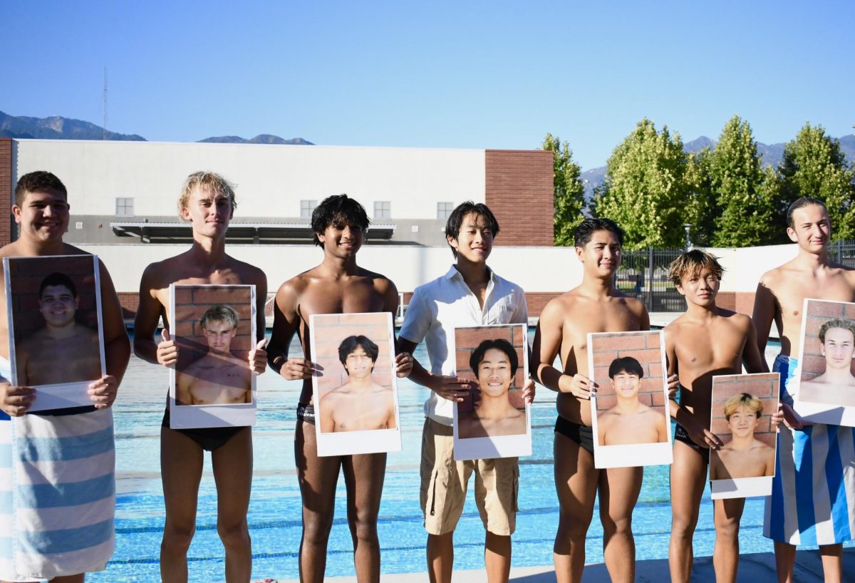The Senior Boys stand with their photos by the poolside!