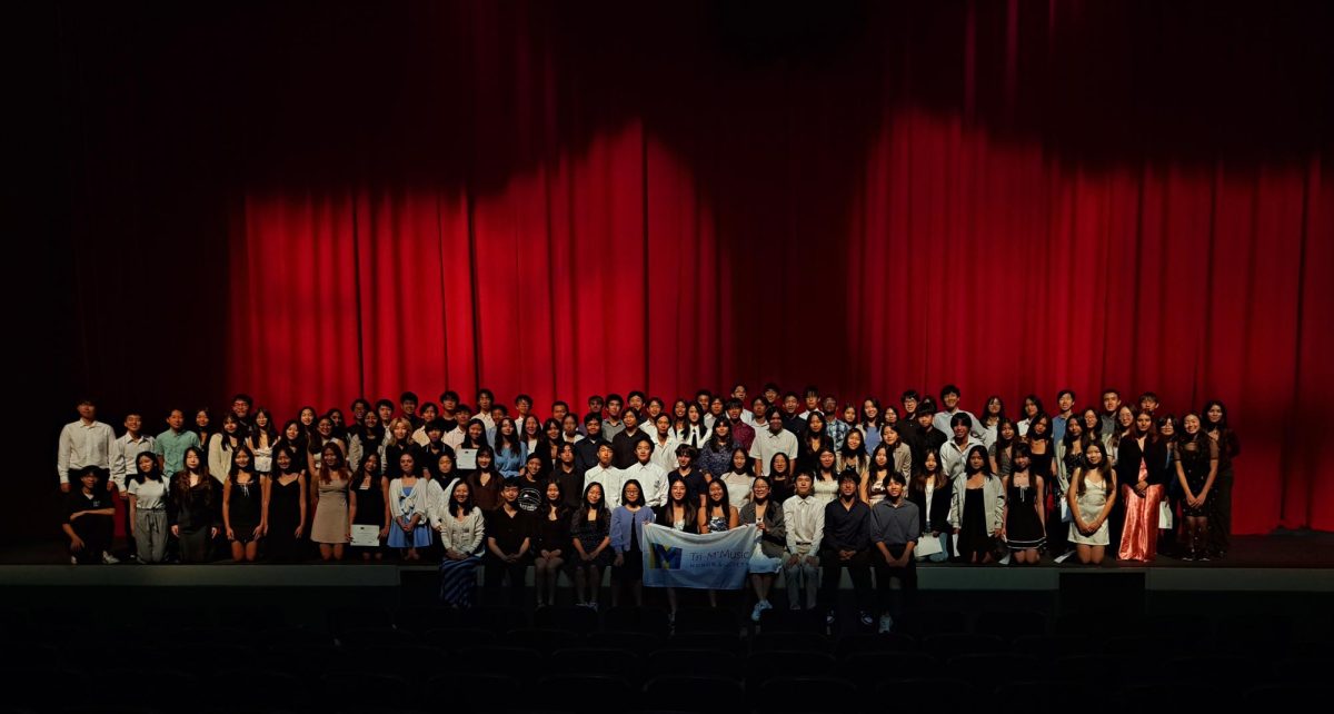 New and returning Tri-M Honor Society members assemble together on the PAC stage.