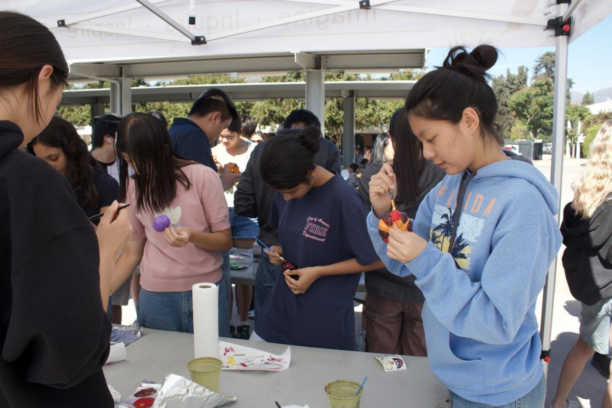 Students at the painting table carefully select their pumpkins and began painting