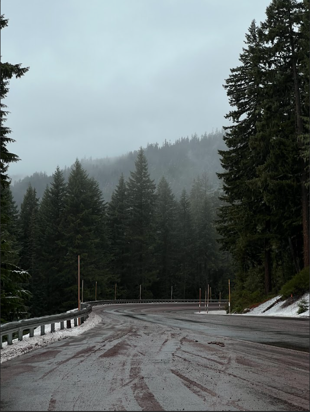 Snow-dusted mountains and a winding scenic road near Crater Lake, Oregon—nature's winter masterpiece.