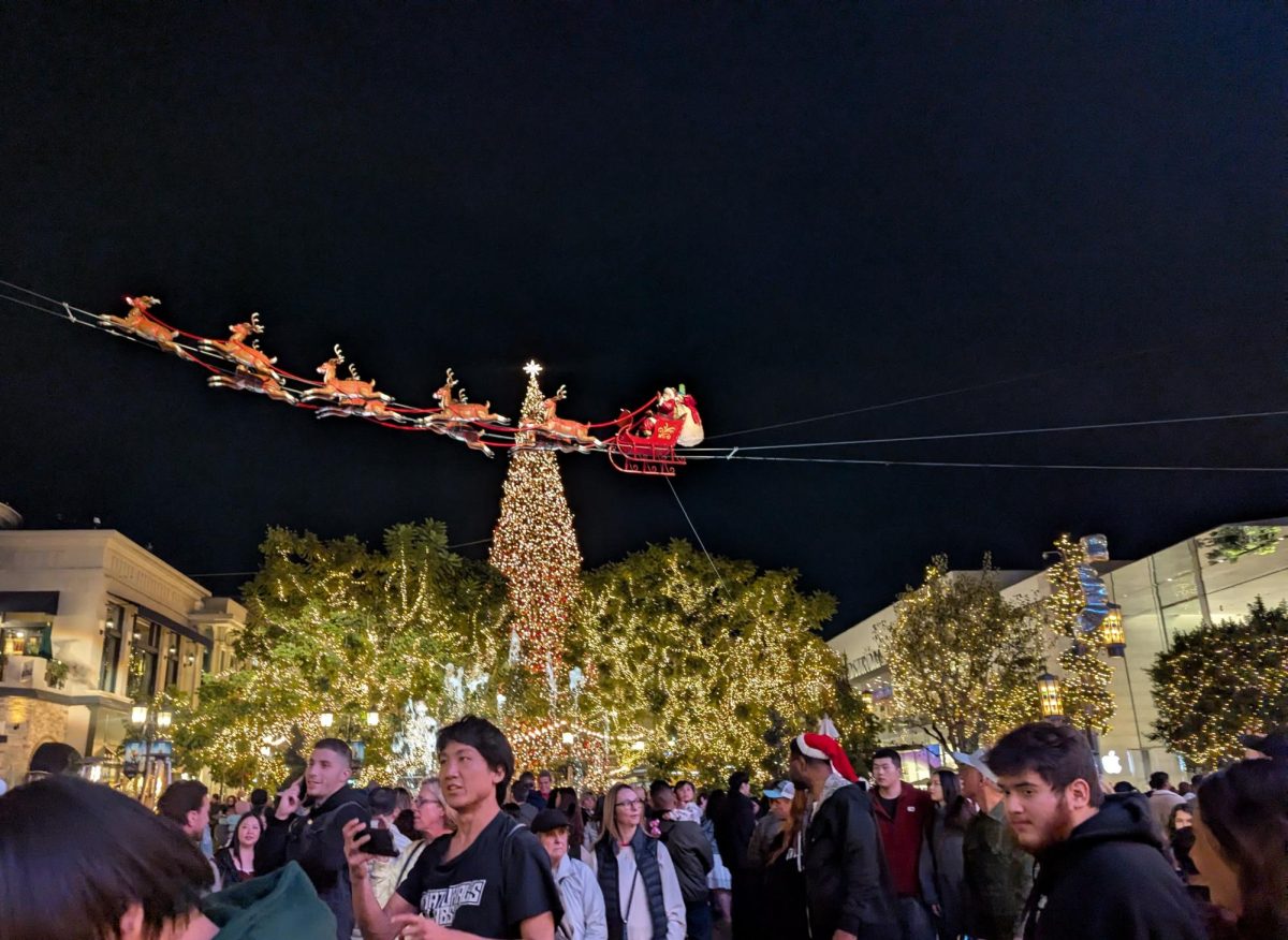 The Grove in Los Angeles during Christmas time. is filled with people wandering around. 