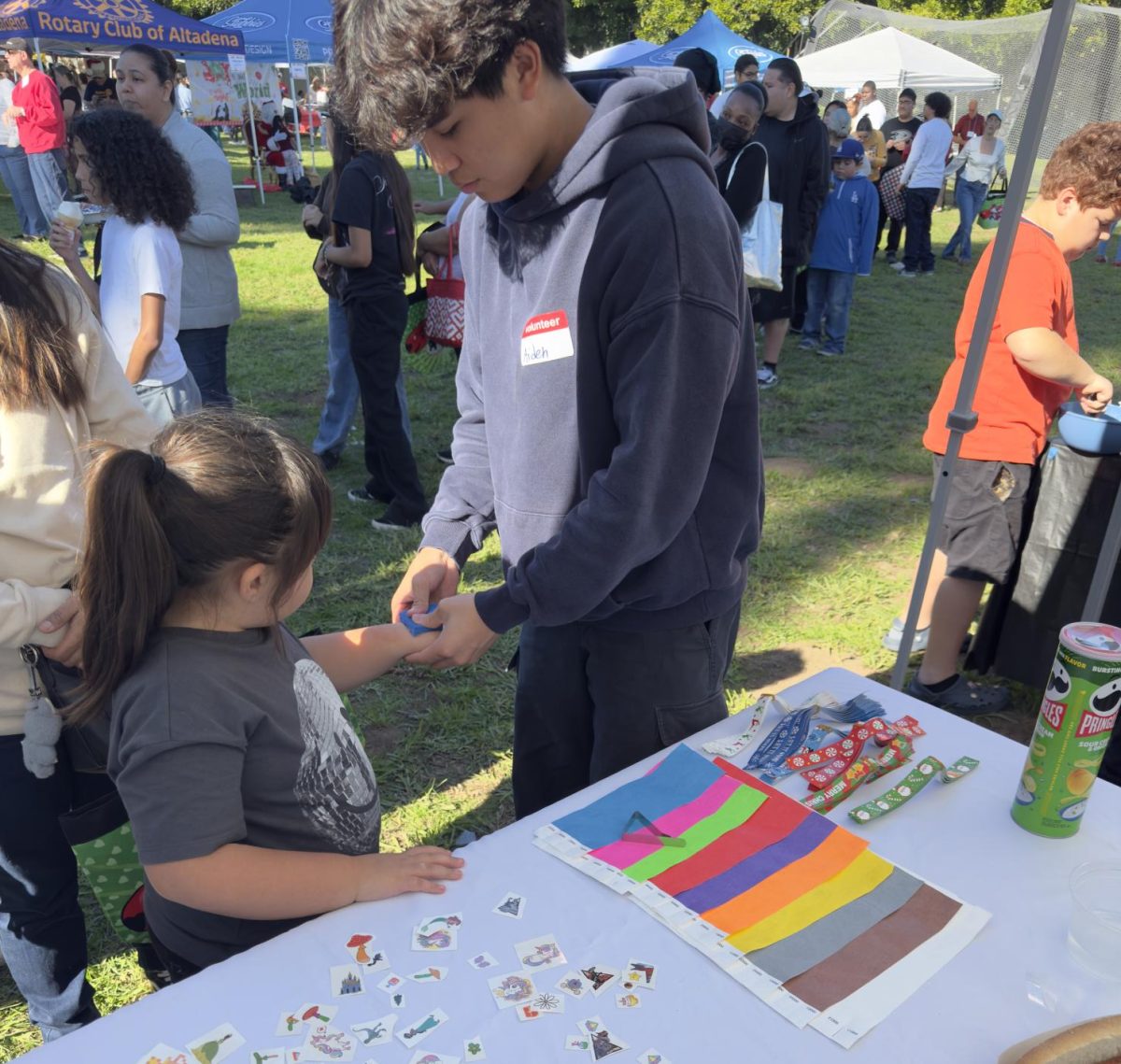 Aiden Cheung putting a tattoo on a young girl at the Christmas festival